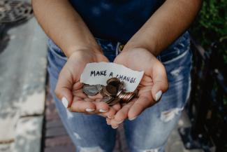 person showing both hands with make a change note and coins by Katt Yukawa courtesy of Unsplash.