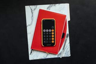 black Android smartphone on red flip case by Kelly Sikkema courtesy of Unsplash.