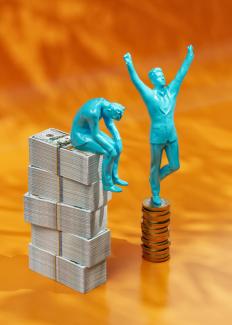 a statue of a man standing on top of stacks of money by Igor Omilaev courtesy of Unsplash.
